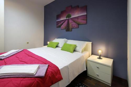 a bedroom with a large white bed with green pillows at Retreat in Rijeka