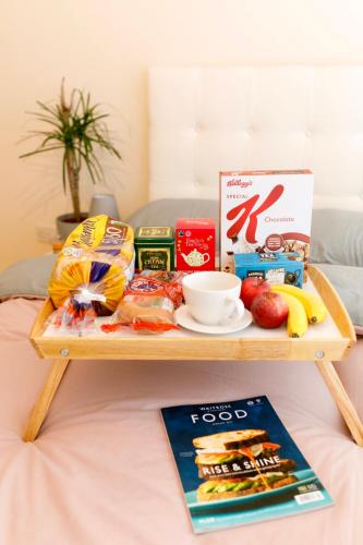 a tray of food on a table on a bed at Central BnB with secure parking in Chester