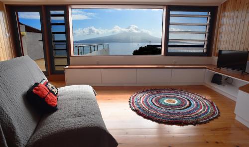 a living room with a couch and a large window at Casa da Paula in Horta