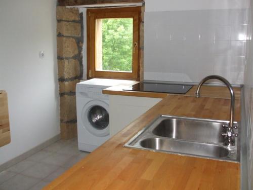 a kitchen with a sink and a washing machine at Las Navedas in Santibáñez de Villacarriedo