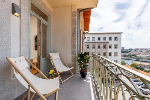 a balcony with chairs and a view of a city at Tripas-Coração, Cordoaria River View, Garden View or Loft in Porto