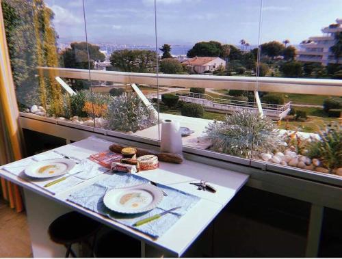 a table in front of a window with a view at Lovely apartment in Marina Baie des Anges- Baronnet - Sew view, free parking spaces on site, restaurants, beach, supermarket in Villeneuve-Loubet