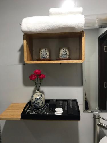 a shelf with a vase with a flower on it at Hanoi Center Silk Lullaby Hotel and Travel in Hanoi