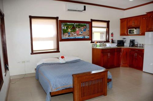 a small bedroom with a bed and a kitchen at Belizean Nirvana in Placencia Village
