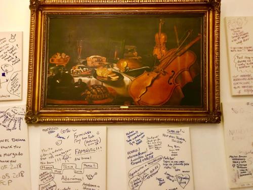 a painting of a violin on a wall with signatures at HOTEL BOUTIQUE a ESPLANADA in Castelo Branco