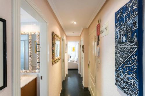 ein Flur mit einem Badezimmer mit Waschbecken und einem Bett in der Unterkunft Fantástico apartamento con piscina in Santa Pola