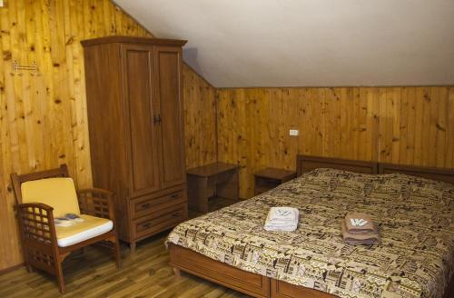 a bedroom with a bed and a cabinet and a chair at Kryvorizka Palanka in Mykulychyn