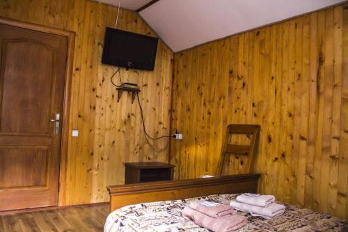 a bedroom with wooden walls and a bed with towels at Kryvorizka Palanka in Mykulychyn