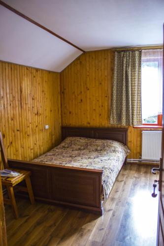 a bedroom with a bed in a room with wooden walls at Kryvorizka Palanka in Mykulychyn