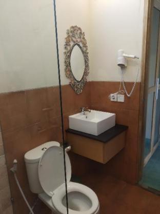a bathroom with a toilet and a sink at Jukung Guest House in Sanur