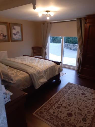 a bedroom with a bed and a sliding glass door at Riverside Lodge in Carlingford