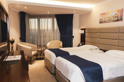Säng eller sängar i ett rum på Erbil International Hotel