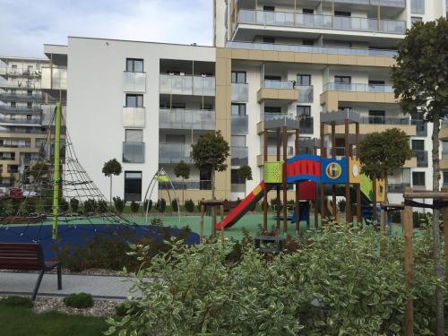 a playground in front of a large apartment building at Marcelin Apartments Poznań in Poznań