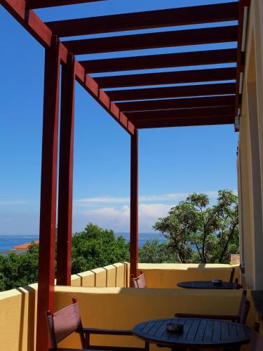 a balcony with a table and chairs and a view of the ocean at Aeriko Benovias Rooms & Apartments in Karfas