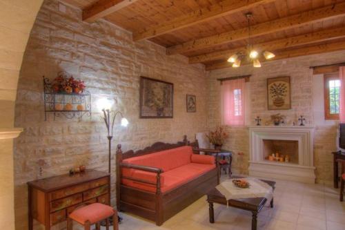 a living room with a red couch and a fireplace at Villa Phaedra in Prinés