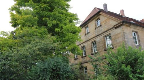 an old brick building with trees in front of it at Hotel-Gasthof Opel Bed & Breakfast in Heinersreuth