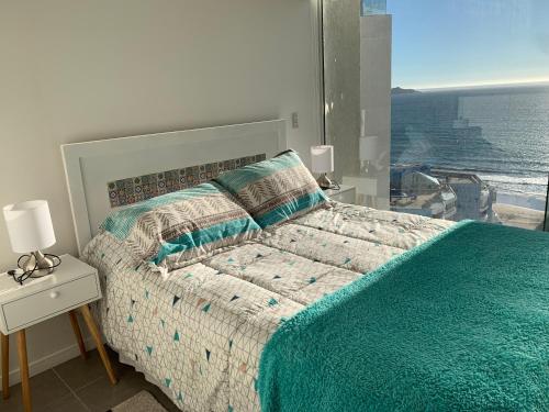 a bedroom with a bed with a view of the ocean at Departamento Club Oceano in Coquimbo