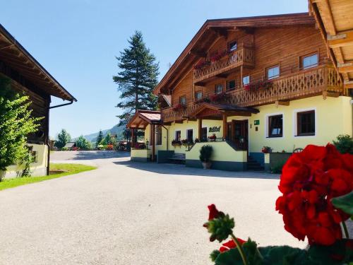 a building in the middle of a road with red flowers at Heisshof in Schladming