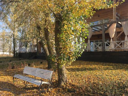a park bench under a tree next to a building at Relax villa Poduzska in Sinyak