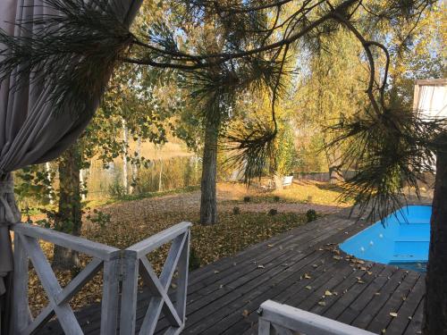 a wooden deck with a chair and a pool at Relax villa Poduzska in Sinyak