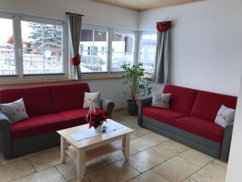 a living room with red couches and a coffee table at Heisshof in Schladming