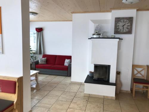 a living room with a red couch and a fireplace at Heisshof in Schladming