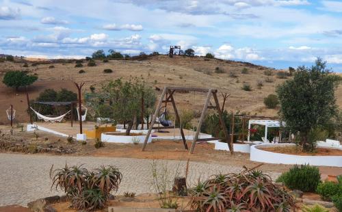 a playground with a swing set on a hill at Monte Do Malhao - Art, Eco & Spa in Castro Marim