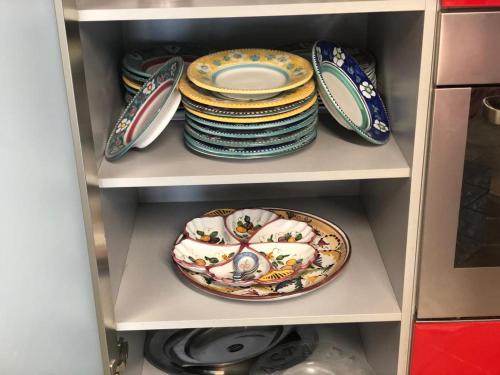 a stack of plates and dishes on a shelf at VILLA FUENTI BAY -Amalfi Coast- in Cetara