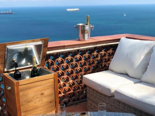 a living room with a couch and wine bottles on a balcony at VILLA FUENTI BAY -Amalfi Coast- in Cetara