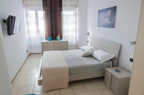 um pequeno quarto com uma cama e uma televisão em Casa vacanze Ķ-HOME em Salerno