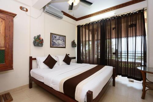 1 dormitorio con 1 cama grande en una habitación en Kovalam Beach Hotel, en Kovalam