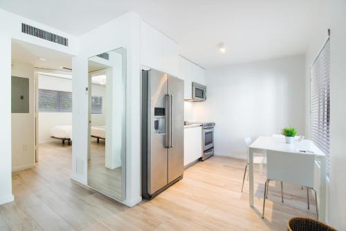 a kitchen with a stainless steel refrigerator and a table at Beach Haus Key Biscayne Contemporary Apartments in Miami
