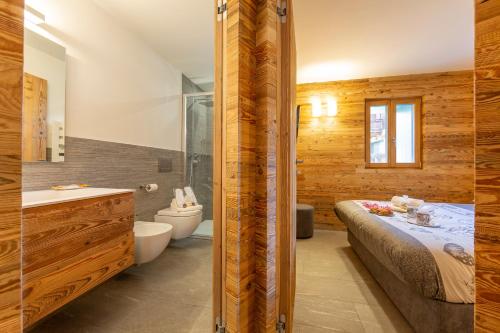 a bathroom with a bed and a tub and a toilet at Marlies Ski in - Ski out Mt 50 - Happy Rentals in Livigno