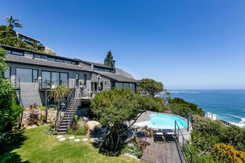 an exterior view of a house with a swimming pool and the ocean at The Gekko Lodge in Cape Town