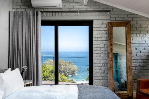 a bedroom with a large window with a view of the ocean at The Gekko Lodge in Cape Town