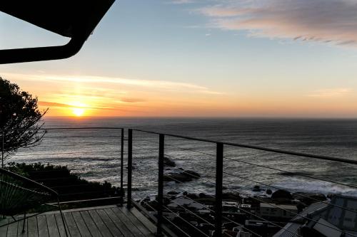 a view of the ocean at sunset from a balcony at The Gekko Lodge in Cape Town