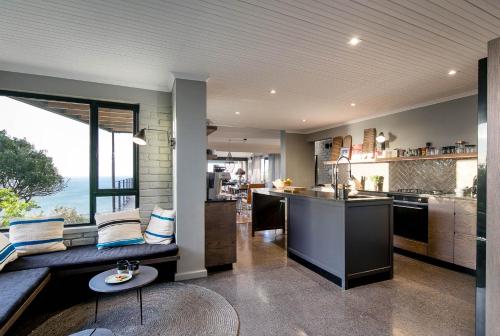 a kitchen and living room with a couch and a table at The Gekko Lodge in Cape Town