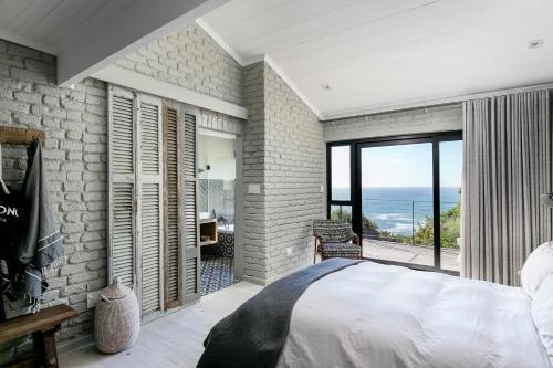a bedroom with a view of the ocean at The Gekko Lodge in Cape Town
