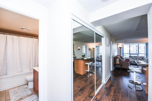 a living room and a kitchen with a mirror at PlanURstay - Luxury Suites Mississauga Downtown in Mississauga