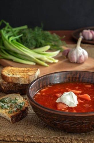 a bowl of soup with bread and vegetables on a table at Relax villa Poduzska in Sinyak