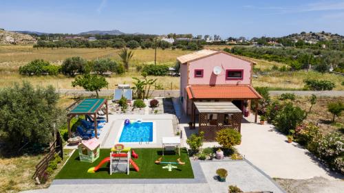een uitzicht op een achtertuin met een zwembad en een huis bij Stergios villa in Kolimbia
