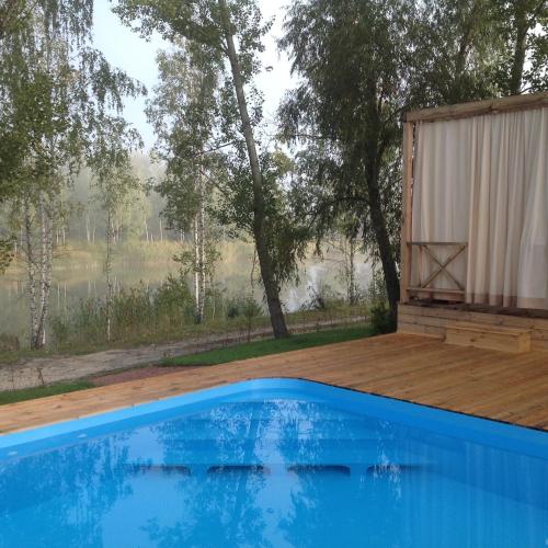 a house with a swimming pool and a wooden deck at Relax villa Poduzska in Sinyak