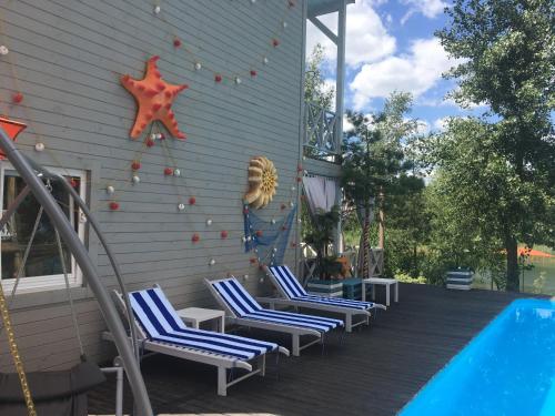 a group of chairs on a deck next to a swimming pool at Relax villa Poduzska in Sinyak