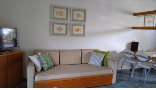 a living room with a couch and a table at Apto no IlhaFlat em frente Mar in Ilhabela