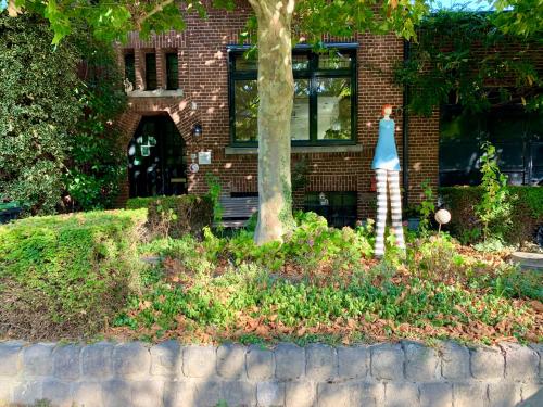 a statue of a woman in front of a brick building at De Auw Sjoekelaatfabriek in Gulpen