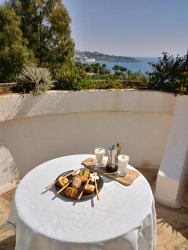 a plate of food on a table with a view of the ocean at La Terrazza on Acquaviva in Marittima