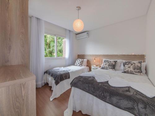 um quarto com 2 camas e uma janela em Residencial Villa Verde - 403 B em Gramado