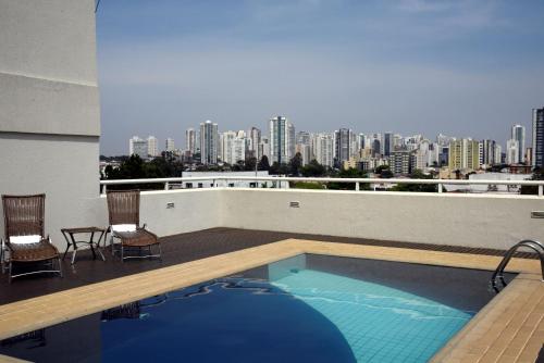 a swimming pool on top of a building with a city skyline at Golden Blue Hotel in Londrina