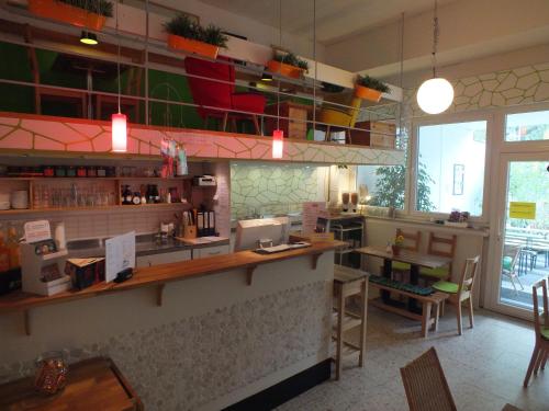 a restaurant with a counter and chairs in a room at Max Hostel in Bonn