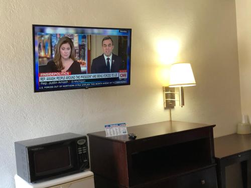 uma televisão de ecrã plano numa parede num quarto de hotel em Economy Inn Alamogordo em Alamogordo